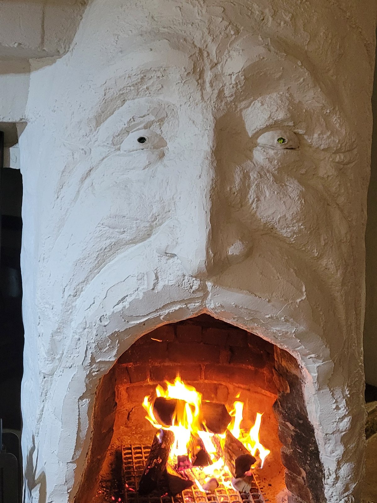 The sculpted wizard-face fireplace at the Storybook Nook
